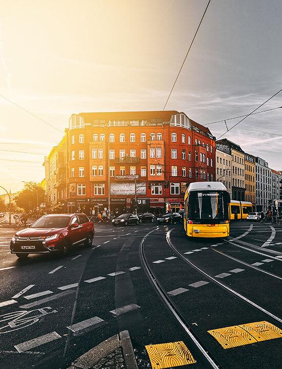 Eine Kreuzung mit Radweg, auf der Straße fahren eine Straßenbahn und Autos